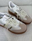 Sneaker con fiocchi oro